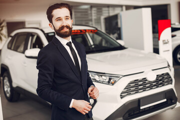 Handsome and elegant man in a car salon