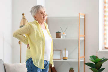 Sticker - Senior woman in shirt suffering from back pain at home