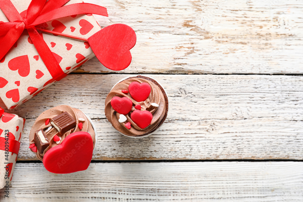 Tasty chocolate cupcakes and gift boxes for Valentine's Day on white background