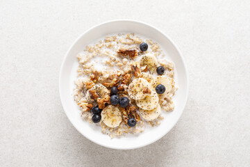 Poster - Oatmeal bowl. Oat porridge with banana, blueberry, walnut, chia seeds and almond milk for healthy breakfast or lunch. Healthy food, diet. Top view.