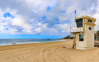 Wall Mural - Vintage lifeguard station in Laguna Beach, famous tourist destination in California, Pacific Ocean in the background a on a cloudy day