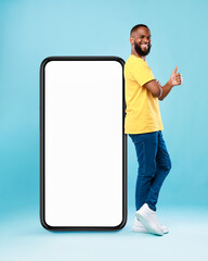 Poster - Funky black guy leaning on giant cellphone, showing thumb up, recommending new mobile app or cool website, mockup