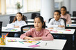 © Prostock-studio - Portrait of focused asian girl sitting at desk in classroom