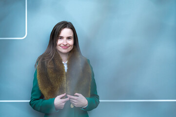 portrait of an elegantly dressed business woman near a blue wall of a modern office building