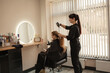 © Вероника Зеленина - .Close-up of female hands holding the hair rows in professional hairstyles salon. The hairdresser paints or makes keratin to a girl in a professional salon