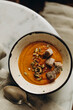pumpkin cream soup in a handmade ceramic bowl. creamy pumpkin soup with croutons, cream and pumpkin seeds. serving creamy pumpkin soup on a marble table.seasonal hot dish