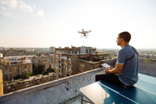 Man Operating A Drone With Remote Control On Rooftop
