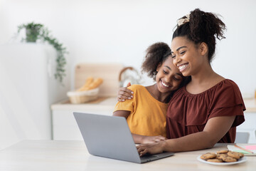 Wall Mural - Cute black mother and kid using laptop together