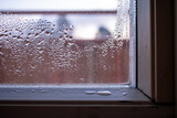 Fototapeta  - Water Droplets and Moisture in Window. Water droplets and moisture form on the egdes of a window caused by the difference in outside and inside temperatures.