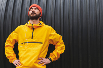 Active man wearing headset listening to music while working out outdoors