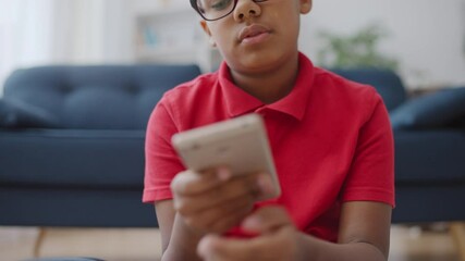 Little boy communicating with friend online, using smartphone app,  bored child