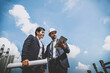 © theevening - Businessman engineer developer with colleague working confident outdoors in the construction site.