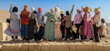 © Frozen Action - Muslimische Mädchengruppe posiert für ein Foto auf einer Steinmauer, Panoramafoto