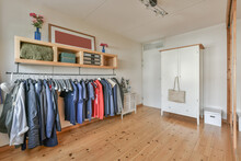 Interior Of Dressing Room With Clothes Hanging On Rack And Wooden Furniture