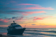 Boat Aground On The Beach With Sunset Colors