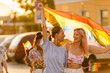 © Drobot Dean - Young lesbian couple walking with rainbow flag during pride parade