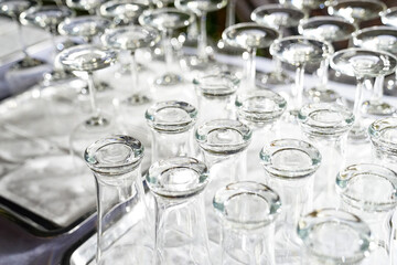 Wine glass and high glass are upside down on the white table in dinner time and ready to use.