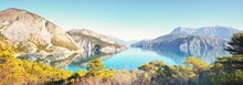 Panoramic View Of The Mountain Lake Lac De Serre-poncon In French Alps On A Sunny Day. Clear Blue Sky, Still Water. Travel Destinations, Tourism, Landmark, Nature, Christmas Vacations In France