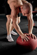 © Roman - Fitness man working out at indoors modern gym using medicine ball.Shirtless caucasian male with muscular body is stretching with cross fit ball. sport, fitness, weight loss, cross fit concept