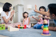 © Kawee - Asian happy family sit on floor, play kid toy together in living room.