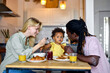 © Roman - Young Family with child having breakfast at home. Happy lifestyle family moments. place where family unites. Beautiful diverse parents taking care of their little child at home. in the morning