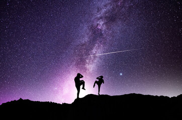 Wall Mural - silhouettes of karate fighters on the background of the starry sky. beautiful milky way galaxy. nigh
