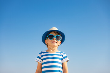 Wall Mural - Happy child having fun outdoor against blue sky