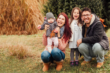 Wall Mural - Family with two daughters having fun in the park