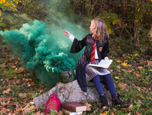  Witch Girl With Magic Wand Cosplay Wizzard Outdoor. Halloween Holiday. Girl Going Green Magic. Green Smoke