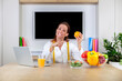 © damianobuffo - Portrait of smiling nutritionist holding a sliced orange, vitamins and healthy diet concept. Dietitian woman with big smile and finger pointing to orange