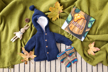 Wall Mural - Baby clothes, toy rabbit, book and autumn decor on color fabric background