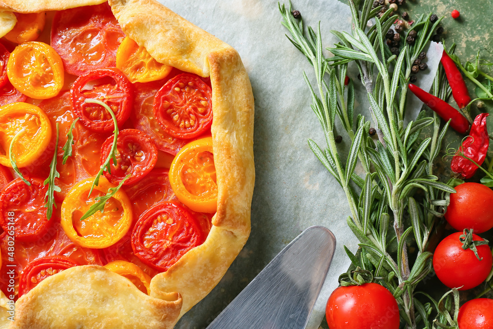 Parchment with tasty tomato galette on table, closeup