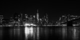 Fototapeta Mosty linowy / wiszący - Partial night view of Manhattan from Brooklyn photographed in black and white
