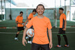 © Odua Images - male futsal player smiling while carrying the ball