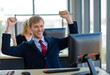 © Bangkok Click Studio - Caucasian happy cheerful lucky success blonde hair male businessman employee in blue formal suit with necktie holding fists up smiling celebrating when looking at computer finish work with customer