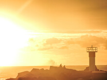 Lighthouse At Sunrise With Golden Glow