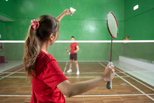 Female Badminton Player Holding Shuttlecock And Racket In Service Position