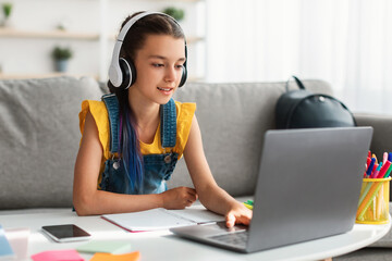 Poster - Girl sitting at desk, typing on keyboard, wearing headset