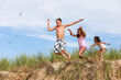 © soupstock - Children jumping off of sand dunes at the beach