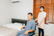 車椅子に座る高齢者男性と介護士の女性