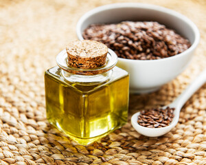 Wall Mural - Flax seeds or linseeds in spoon and bowl with glass of linseed oil