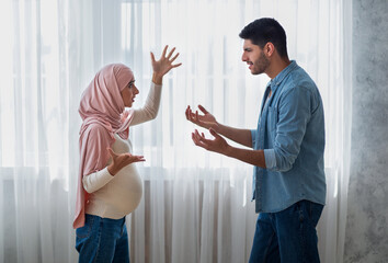 Canvas Print - Pregnancy and relationship problems. Pregnant arab woman arguing with husband at home, side view