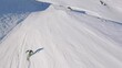 Epic dynamic fpv aerial following a man skiing down a ski slope in the swiss alps