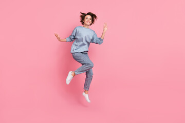 Full length photo of cool millennial lady jump wave wear jumper jeans footwear isolated on pink background