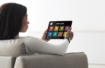 Poster - African american woman holding digital pad with smart house app