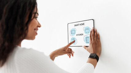 Poster - Woman turning on light at kitchen, using smart home system