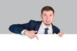 © Larisa - The businessman points with his index finger at the white blank board