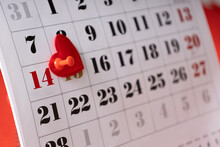 Closeup Of White Calendar Page And Red Number 14 February.Valentines Day.Push Pin And Decorative Heart On The Calendar