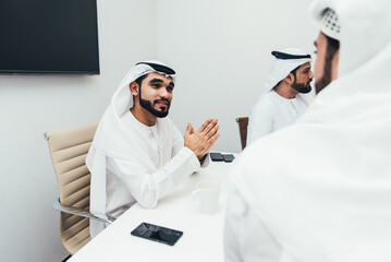 Wall Mural - Group of business managers from the emirates meeting and working together in Dubai. Arabian businessmen wearing traditional clothes