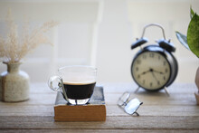 Coffee Glass Cup And Old Book And Clock On Wooden Table
